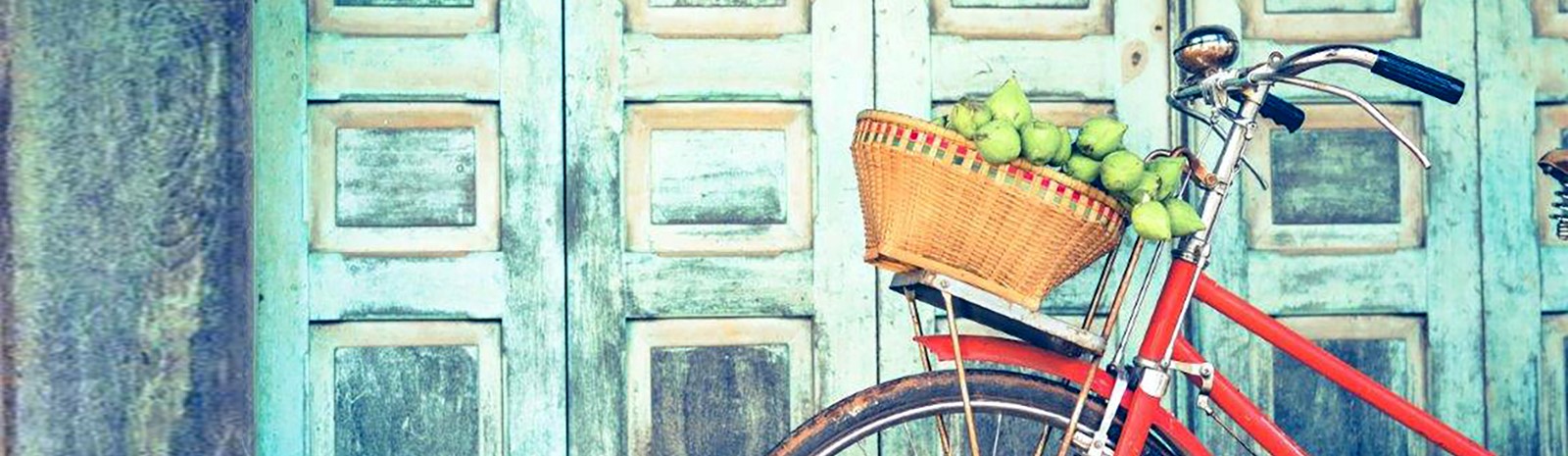 Red bicycle with fruit in basket